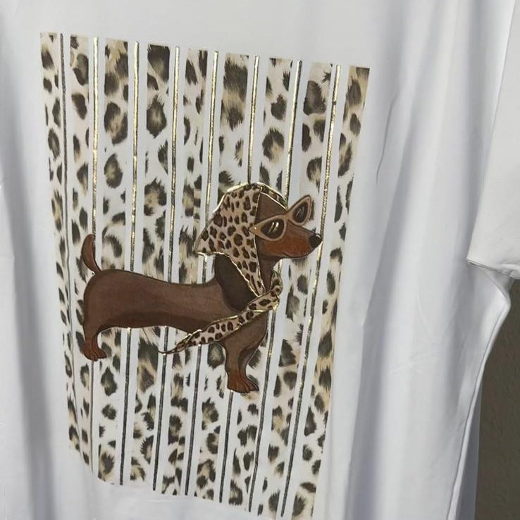 Camiseta blanca PINTONAS de talla única con estampado de perro salchicha estilo Marilyn con gafas y pañuelo de leopardo y detalles dorados.