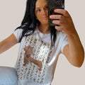 Camiseta blanca de PINTONAS con estampado de perrito estilo Marilyn en tonos marrones y detalles dorados.