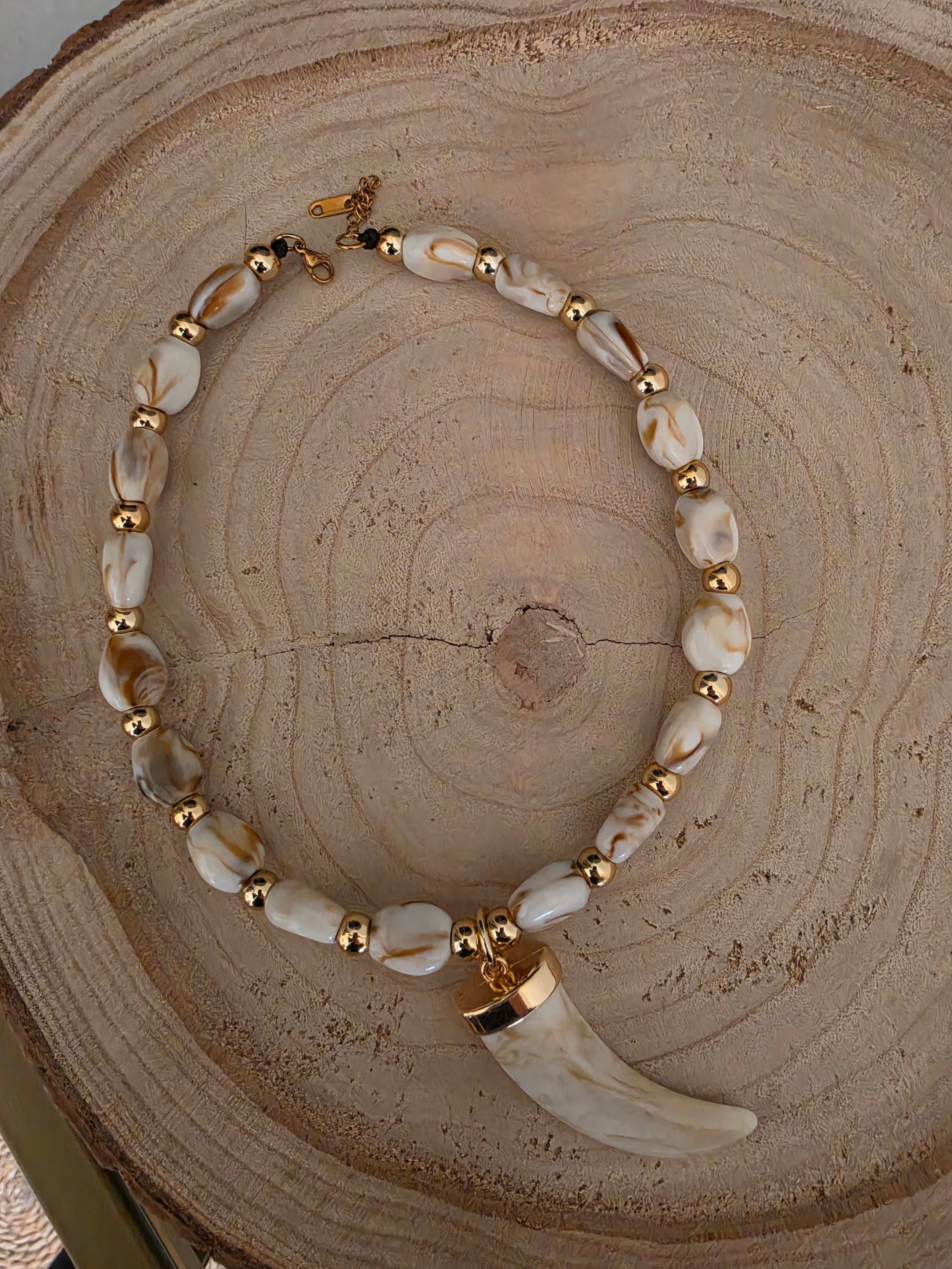Collar PINTONAS de cuerno marfil con cuentas doradas y colgante de colmillo. Diseño étnico.