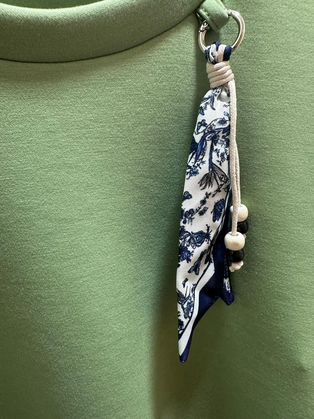 Conjunto PINTONAS de chándal deportivo verde con detalle de pañuelo estampado y cuentas.