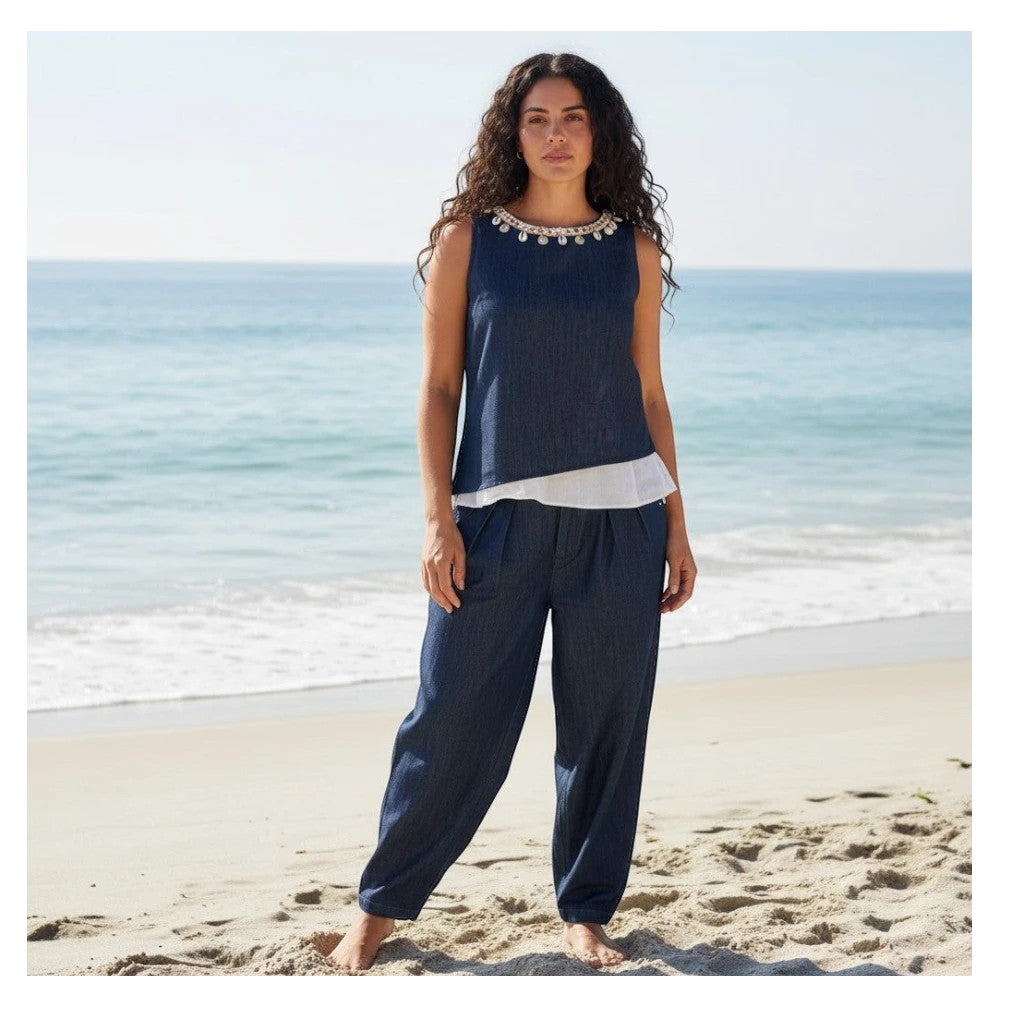 Conjunto PINTONAS de denim azul oscuro con top sin mangas y cuello joya adornado con cadena y conchas, y pantalón palazzo con pinzas.