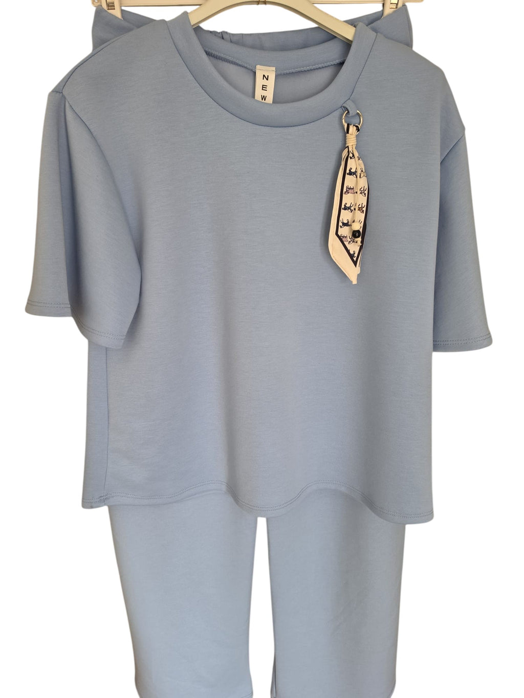 Conjunto deportivo PINTONAS de tejido tactel azul claro, con camiseta de manga corta y pantalón, detalle de pañuelo estampado.
