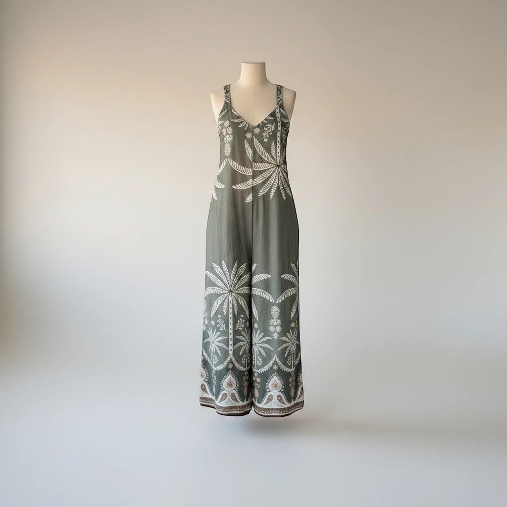 Mono PINTONAS verde con estampado de palmeras blancas y detalles étnicos en pierna ancha y escote en V.