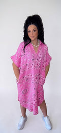Vestido PINTONAS rosa de algodón con estampado bandana, cuello en V y corte oversize. Largo midi y bolsillos laterales.