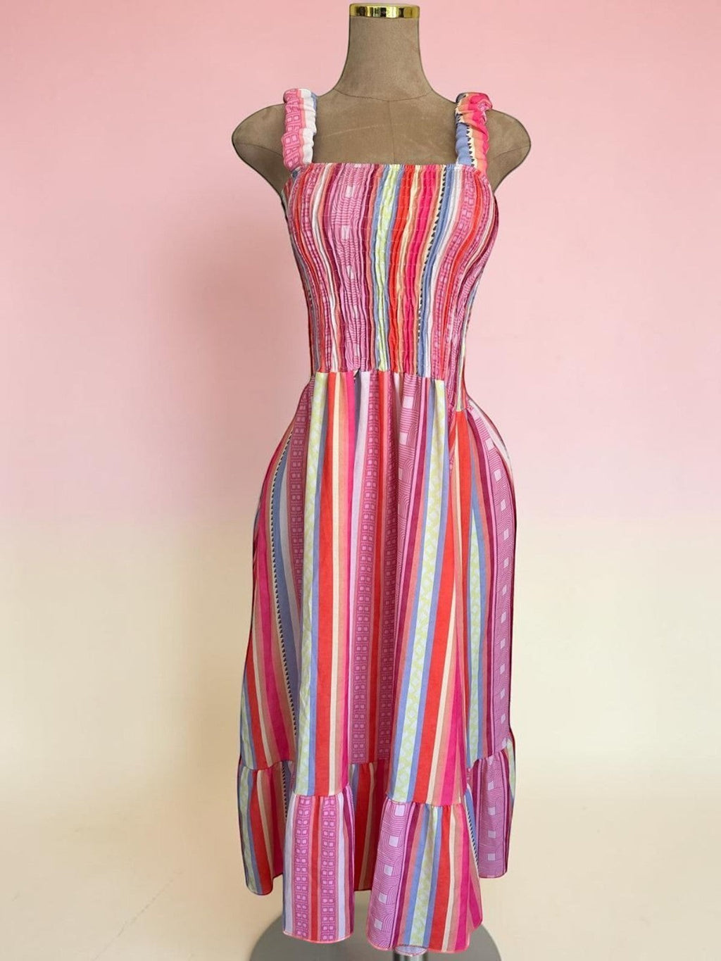 Vestido midi PINTONAS de rayas verticales multicolor con cuerpo fruncido nido de abeja y volante en el bajo. 50% Viscosa/50% Poliéster.