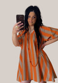 Vestido PINTONAS de rayas verticales naranjas y beige, manga abullonada, cuello en V.