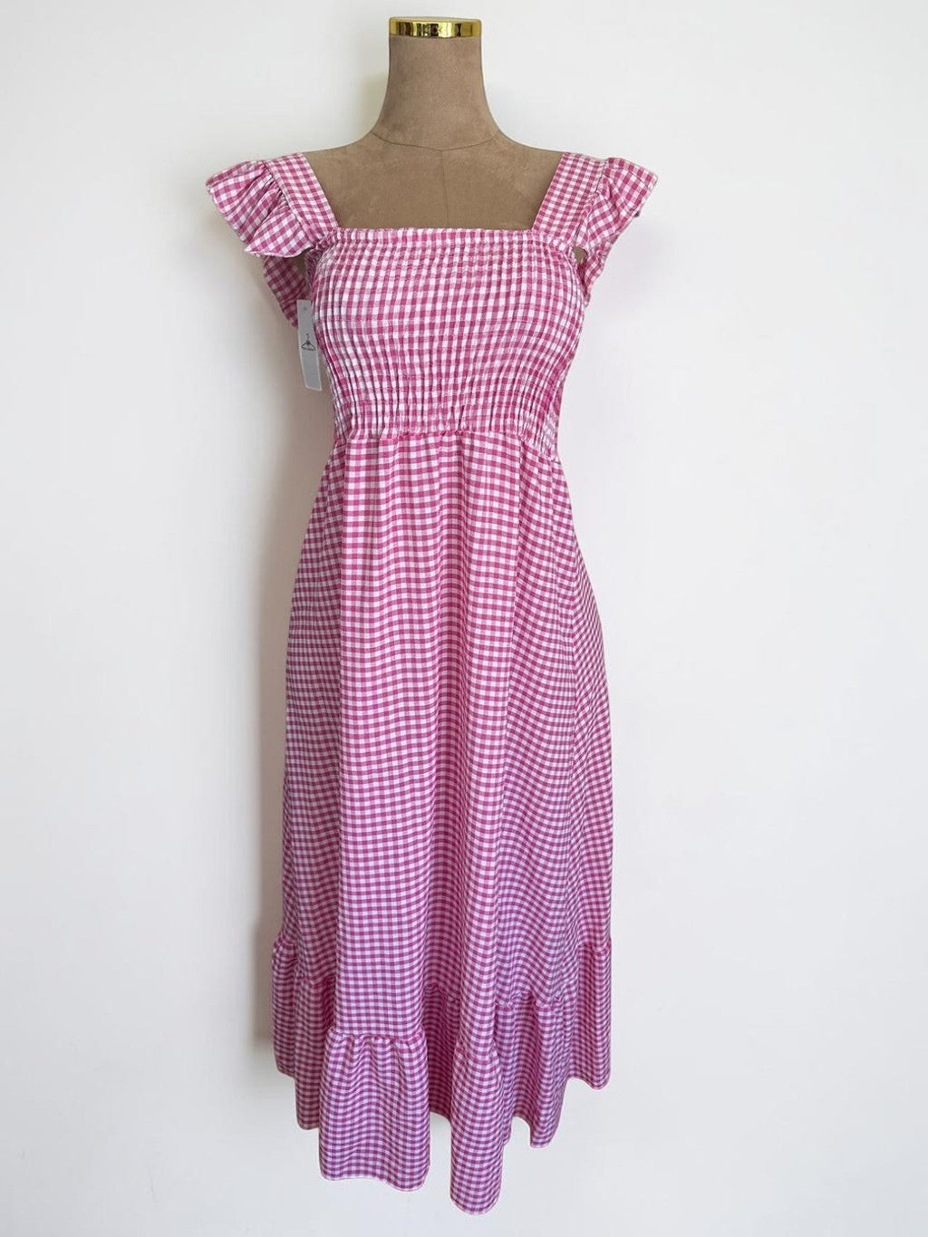 Vestido midi PINTONAS de cuadros vichy rosa y blanco, con cuerpo fruncido de nido de abeja y mangas volante.